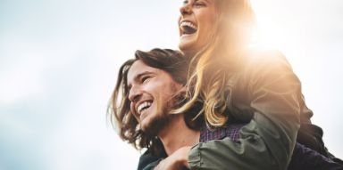 Man giving a woman a piggyback ride outdoors